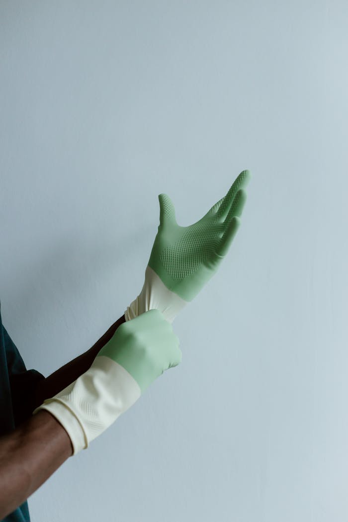 services-03 A person wearing green latex gloves, ready for cleaning tasks, with space for text.