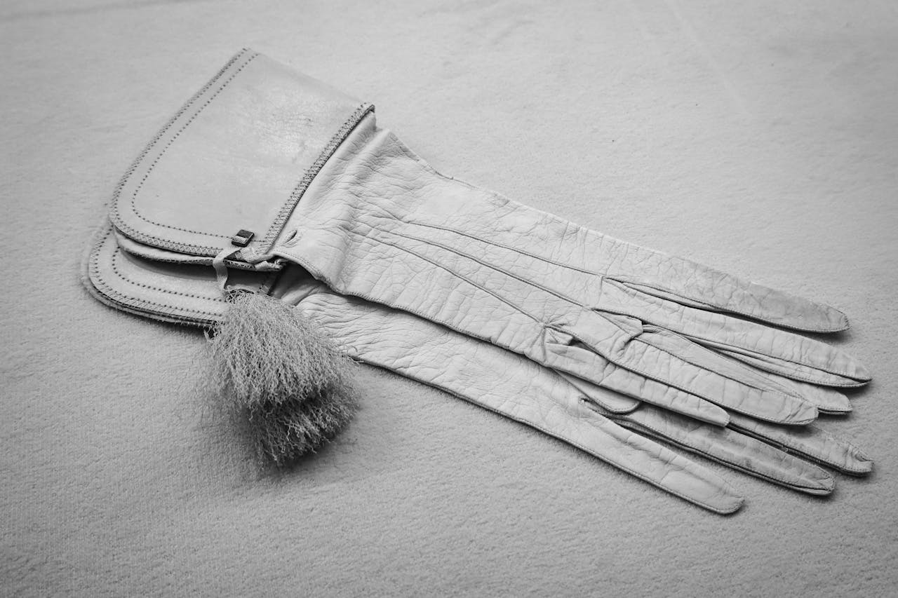 hero-img-02 Elegant vintage leather gloves with tassel detail in a monochrome setting.